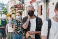 Middle aged man wearing mask waiting, standing in line, respecting social distancing to collect his takeaway order from