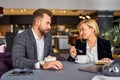 middle-aged man and woman discussing business ideas, at meeting