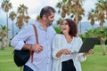 Middle-aged man and woman looking into the laptop screen outdoors Royalty Free Stock Photo