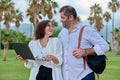 Middle-aged man and woman looking into the laptop screen outdoors Royalty Free Stock Photo