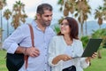 Middle-aged man and woman looking into the laptop screen outdoors Royalty Free Stock Photo