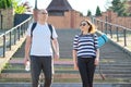 Middle-aged man and woman in sportswear talking walking
