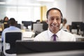 Middle aged man working at computer with headset in office Royalty Free Stock Photo