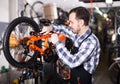 Middle-aged mechanic is working on master bicycle assembly Royalty Free Stock Photo
