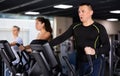 Middle aged man in the gym is engaged in sports using an ellipsoid simulator. Healthy lifestyle and sport concept Royalty Free Stock Photo