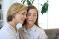 Middle aged mother and daughter talking on sofa in living room Royalty Free Stock Photo