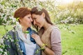 Middle-aged mother and her daughter hugging in blooming garden Royalty Free Stock Photo