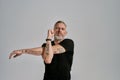 Middle aged muscular man in black sportswear looking at camera while warming up his body before workout in studio over Royalty Free Stock Photo