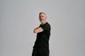 Middle aged muscular man in black sportswear looking at camera while warming up his body before workout in studio over Royalty Free Stock Photo