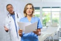 Upset middle-aged nurse standing with her back to angry doctor Royalty Free Stock Photo