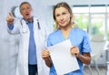 Upset middle-aged nurse standing with her back to angry doctor Royalty Free Stock Photo