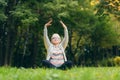 Older woman sits on the grass and doing sports exercises doing yoga Royalty Free Stock Photo