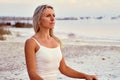 Middle aged 50s yogi woman meditating on nature