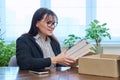 Middle-aged joyful woman with new books unpacked from cardboard box Royalty Free Stock Photo