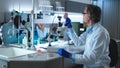 Middle aged scientist examining cell meat near colleagues Royalty Free Stock Photo