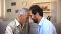 Middle-aged and senior males touching foreheads good relations between relatives