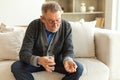 Middle aged senior man holding medical pill and glass of water. Mature old senior grandfather taking medication cure Royalty Free Stock Photo