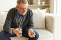 Middle aged senior man holding medical pill and glass of water. Mature old senior grandfather taking medication cure Royalty Free Stock Photo