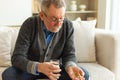 Middle aged senior man holding medical pill and glass of water. Mature old senior grandfather taking medication cure Royalty Free Stock Photo