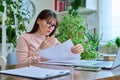 Middle-aged serious woman working at computer laptop in home office Royalty Free Stock Photo