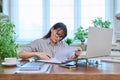 Middle-aged serious woman working at computer laptop in home office Royalty Free Stock Photo