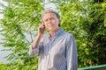 Middle-aged soft skin man in striped shirt on phone