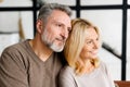 Middle-aged spouses sits on the sofa at home and look aside at one way Royalty Free Stock Photo