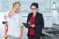 Middle aged supervising telling off trainee in kitchen Royalty Free Stock Photo