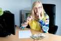 Middle-aged thoughtful woman counting euro money and takes notes at a desk in the home office Royalty Free Stock Photo