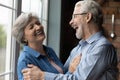 Middle-aged untroubled couple hugging laughing while standing indoor Royalty Free Stock Photo