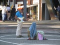 A middle aged well dressed street busker playing the guitar in Stanley square