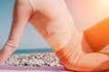 Woman sea pilates. Sporty happy middle aged woman practicing fitness on beach near sea, smiling active female training Royalty Free Stock Photo