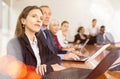 Middle aged white brunette businesswoman sitting at meeting and watching presentation Royalty Free Stock Photo