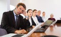 Middle aged white business man yawning at boring meeting Royalty Free Stock Photo