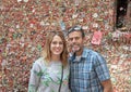 Middle-aged wife and husband in front of The Market Theater Gum Wall, Pike Place Market, Seattle, Washington