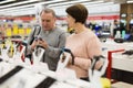 Middle aged wife and husband picking new smartphone in electronic store Royalty Free Stock Photo