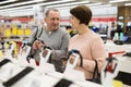 Middle aged wife and husband picking new smartphone in electronic store Royalty Free Stock Photo