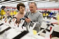 Middle aged wife and husband picking new smartphone in electronic store Royalty Free Stock Photo
