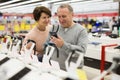 Middle aged wife and husband picking new smartphone in electronic store Royalty Free Stock Photo