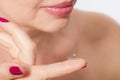 Middle aged woman applying or putting contact lens for vision in her brown eye by finger. Close up and isolated. Selective focus Royalty Free Stock Photo