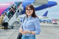 Middle aged woman with backpack, passengers boarding plane background Royalty Free Stock Photo