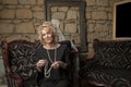 Middle aged woman in black dress sitting on sofa