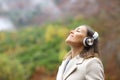 Middle aged woman breathing fresh air with headphones in a forest Royalty Free Stock Photo