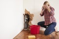 Middle aged woman with a burst water pipe phoning for help Royalty Free Stock Photo