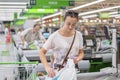 A middle-aged woman at the checkout in the supermarket. The woman counts on the checkout in the supermarket. Royalty Free Stock Photo