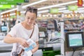 A middle-aged woman at the checkout in the supermarket. The woman counts on the checkout in the supermarket Royalty Free Stock Photo