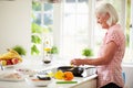 Middle Aged Woman Cooking Meal In Kitchen Royalty Free Stock Photo