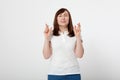 Middle aged woman crossing her fingers and wishing for good luck. Blank white t-shirt, mock up. Fashion outfit Mother day Royalty Free Stock Photo