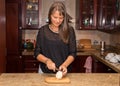 Middle aged woman cutting a white onion.