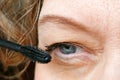 Middle-aged woman does corrective eye makeup to correct the drooping eyelid. Ptosis is a drooping of the upper eyelid, lazy eye. Royalty Free Stock Photo